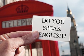 Britische Telefonzelle, im Vordergrund ein Zettel mit der Aufschrift Do you speak English